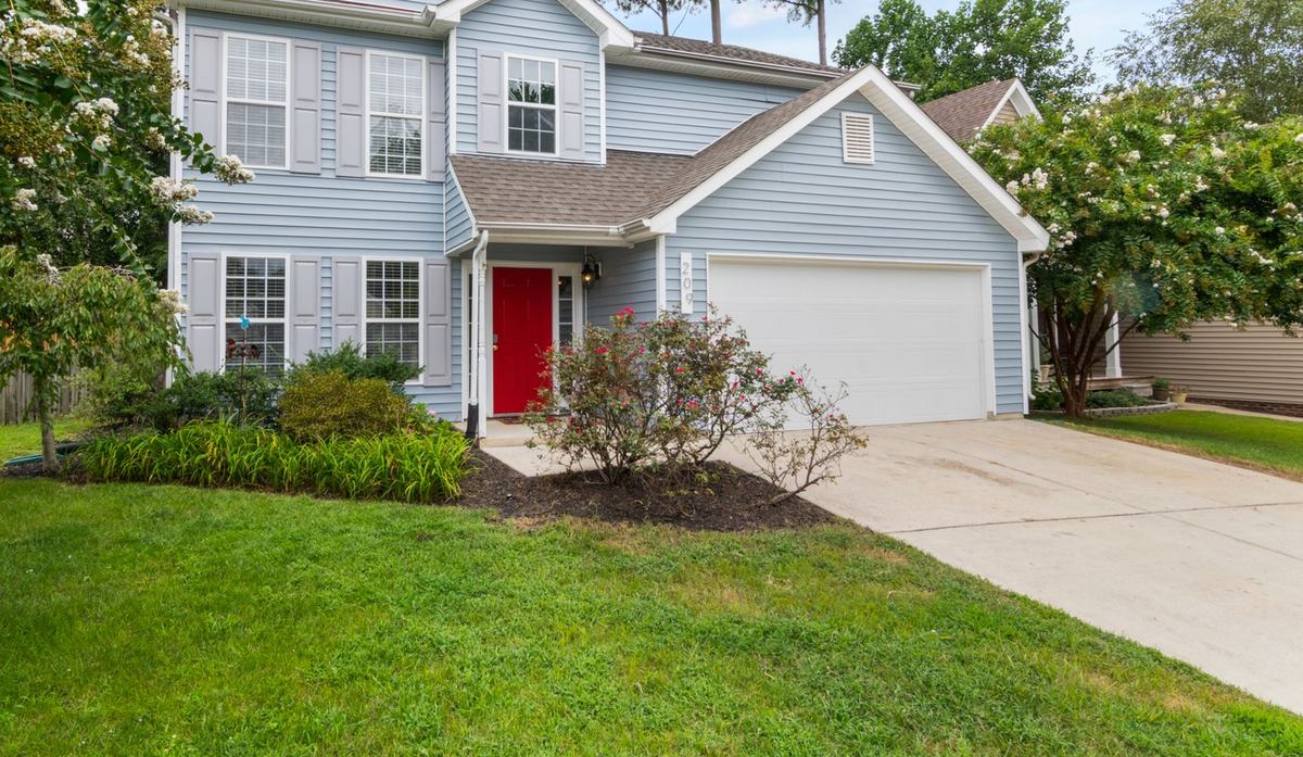 A mown front lawn with a mulched planting bed running along a driveway.